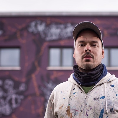 Portrait of Jens Besser in front of a large sized mural by Jens Besser - photo by Sven Ellger